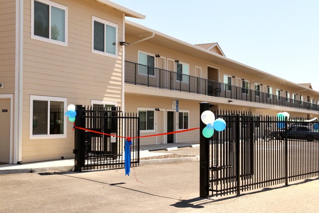Beige building with black gate and balloons.